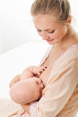 Young mother breastfeeds her baby. Breast-feeding.