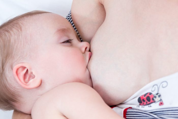 Mother breastfeeding her baby falling asleep breast closeup