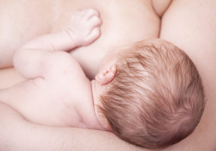 Close-up of a newborn baby breastfeeding