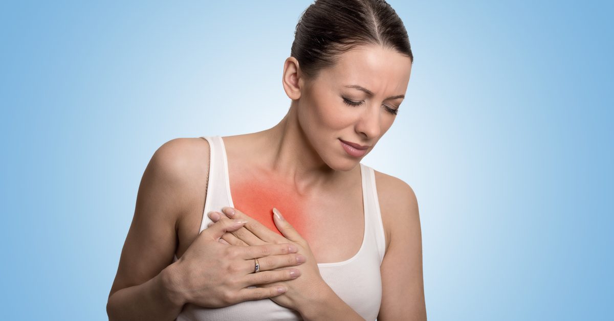 Young woman with chest breast pain colored in red isolated on blue background