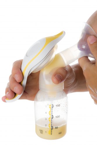 Mother getting milk with a manual breast pump isolated on a white background