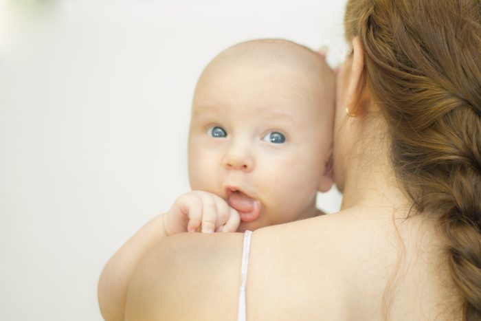 Beautiful newborn baby boy in the arms of his mother